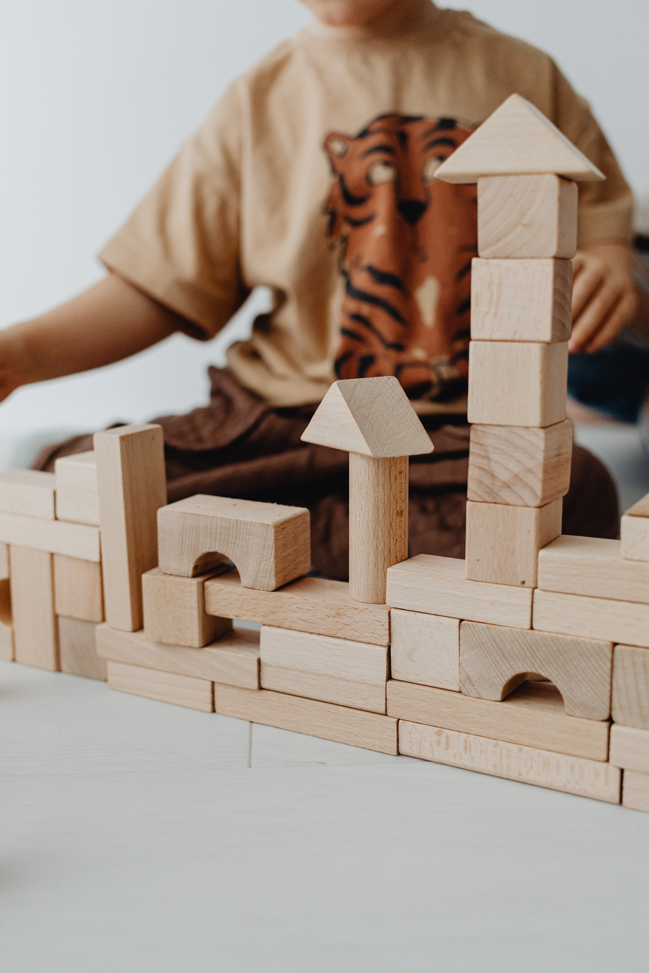 Photograph of Wooden Building Blocks Near a Kid